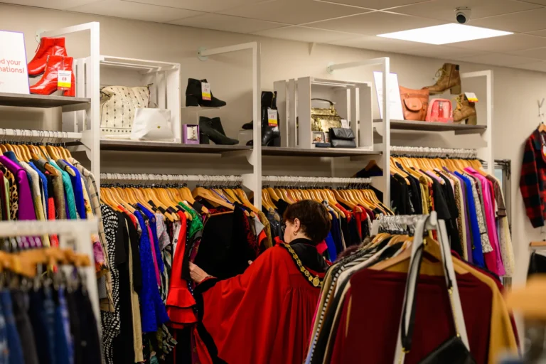 Maac Ross On Wye There Are Many Clothes On Racks In A Store With A Woman Looking At Them