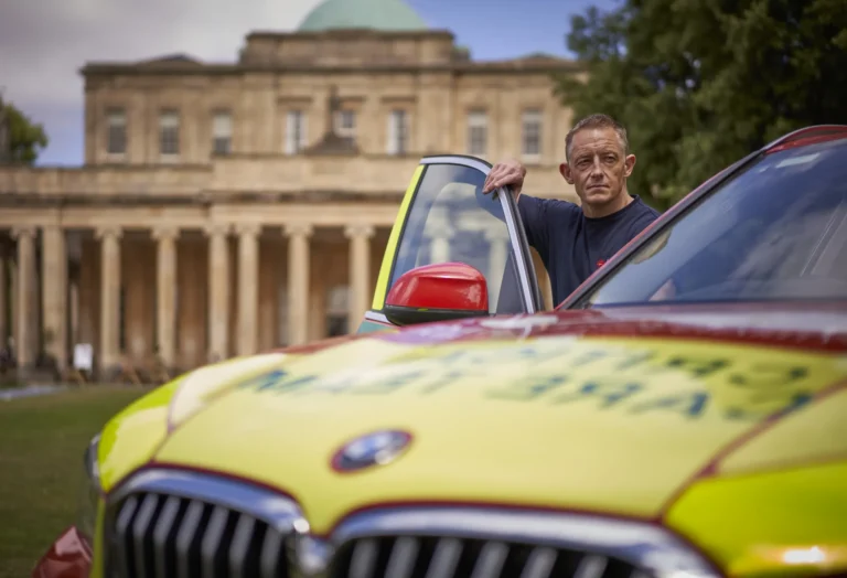 Maac Gloucestershire There Is A Man Standing Next To A Yellow Car With A Yellow Sign On It