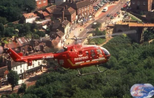 Maac Helicopter Flying Over A City With A Lot Of Buildings