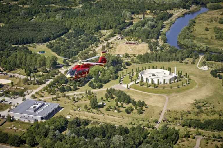 A Midlands Air Ambulance helicopter flying over Staffordshire countryside, with a river in view.