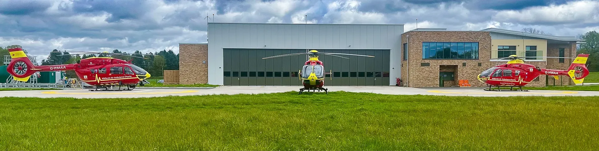 Maac There Are Three Large Red And Yellow Helicopters Parked In Front Of A Building