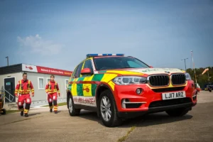 Maac There Is A Red And Yellow Car With A Fireman Walking By