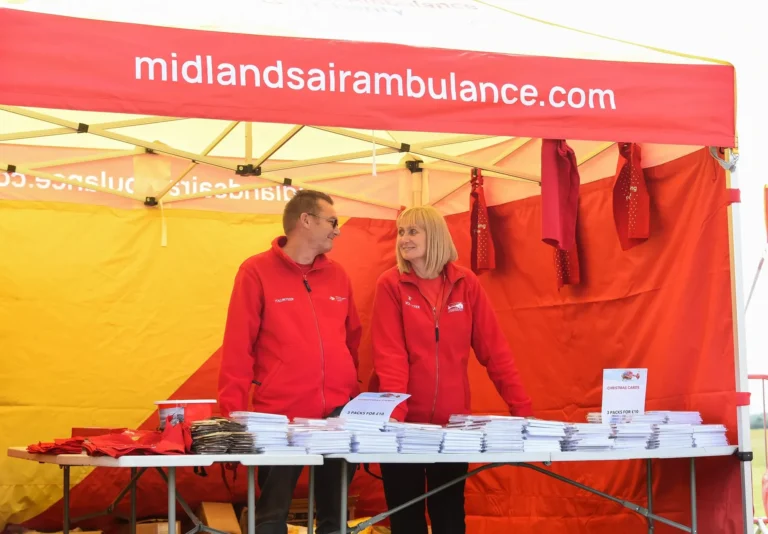 Maac They Are Standing Under A Tent With A Table Full Of Books