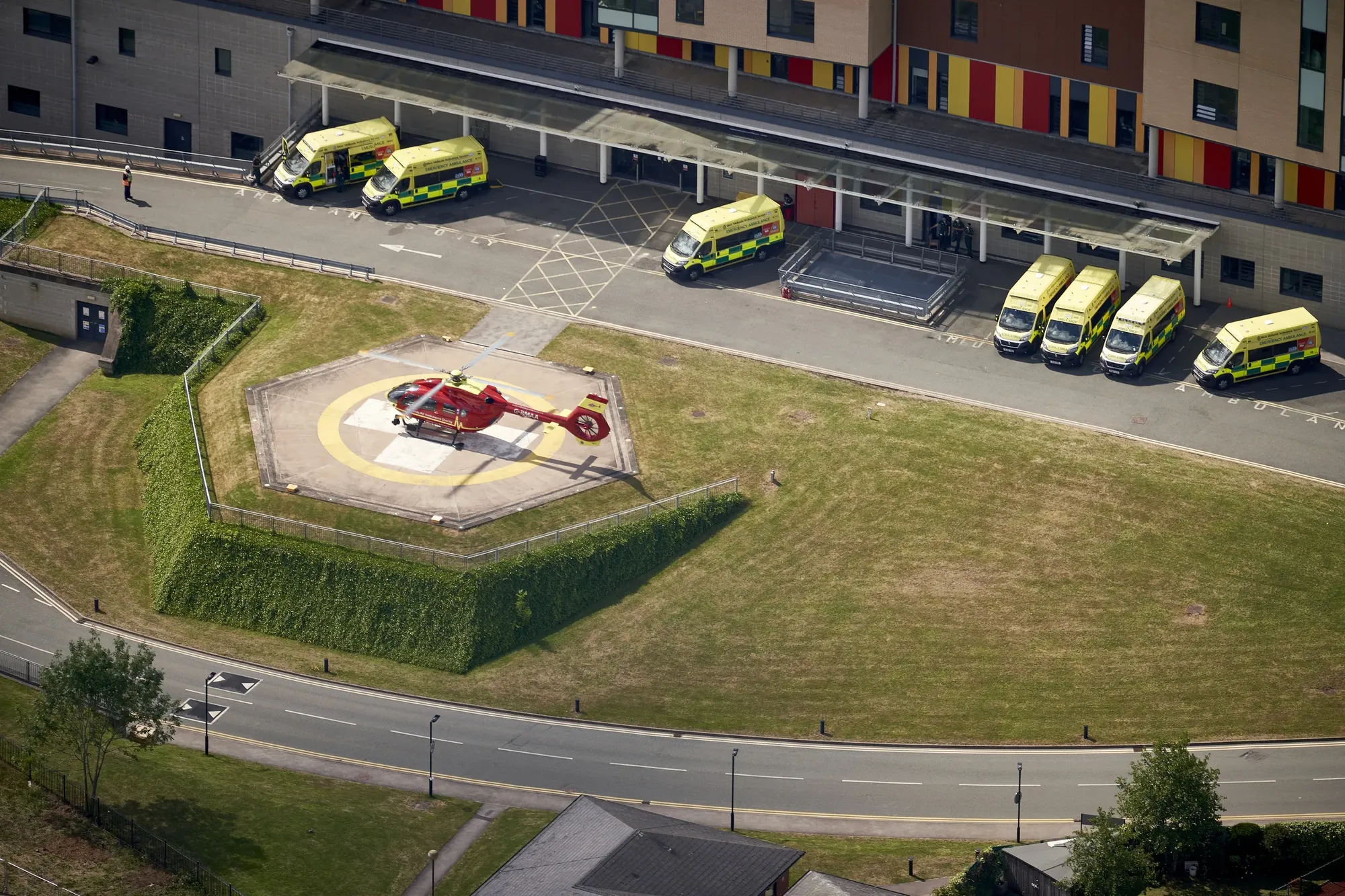 Maac Aerial View Of A Helicopter Parked In A Parking Lot Next To A Building