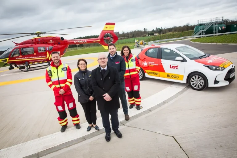 Maac Air Ambulance Team Standing In Front Of A Car And A Helicopter