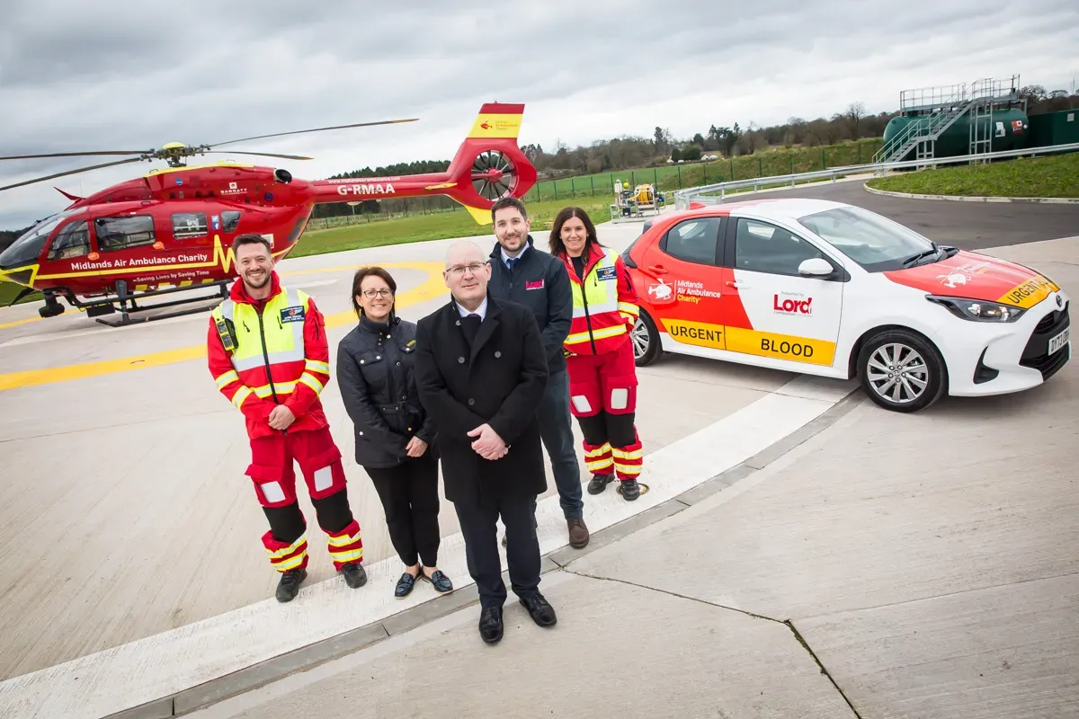 Maac Air Ambulance Team Standing In Front Of A Car And A Helicopter