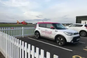 Maac Car Parked In A Parking Lot Next To A White Fence