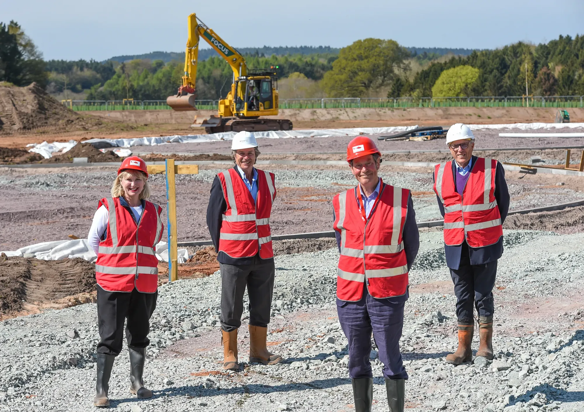Maac Four People In Safety Vests And Hard Hats Standing On A Construction Site
