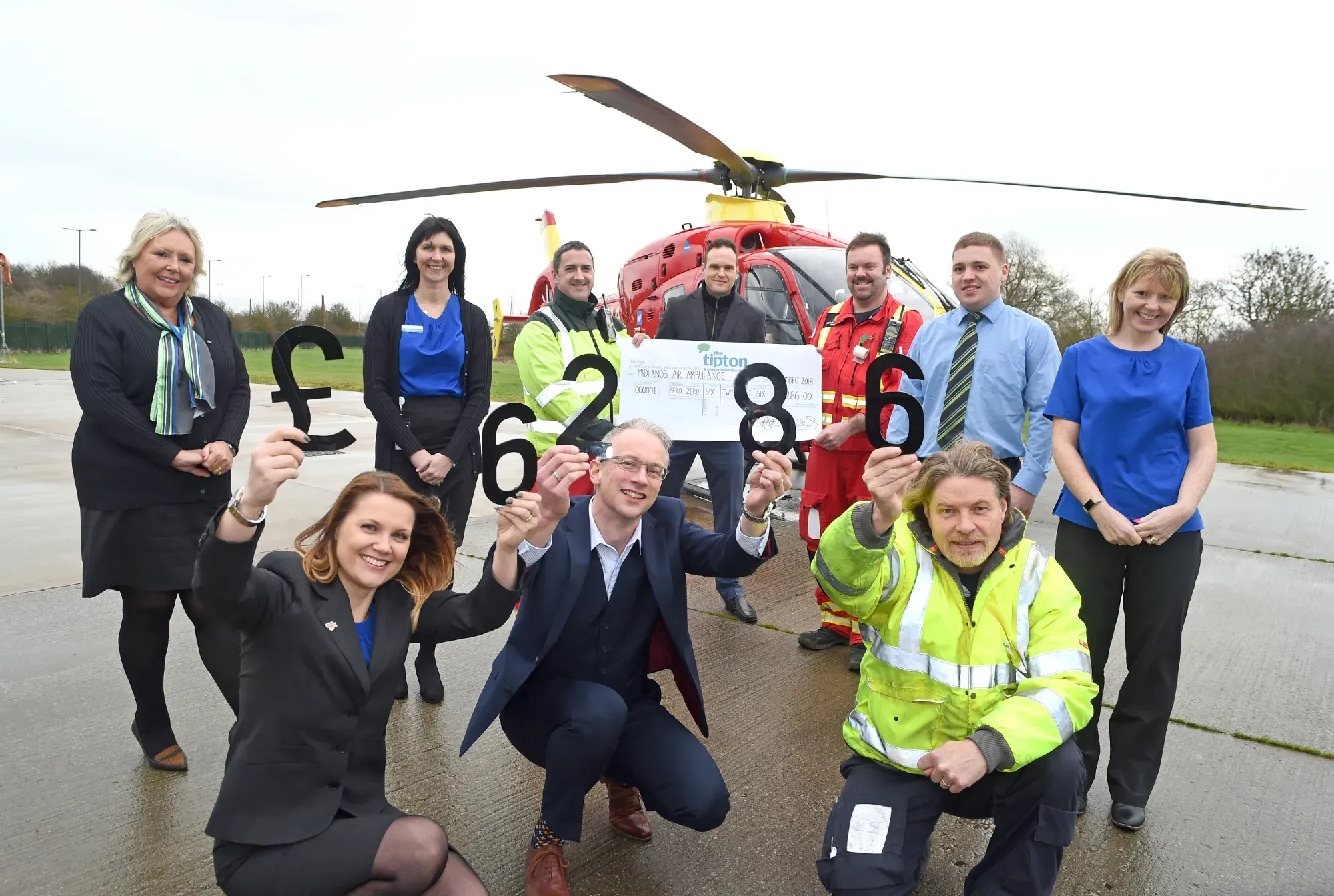 Maac Group Of People Posing For A Picture In Front Of A Helicopter