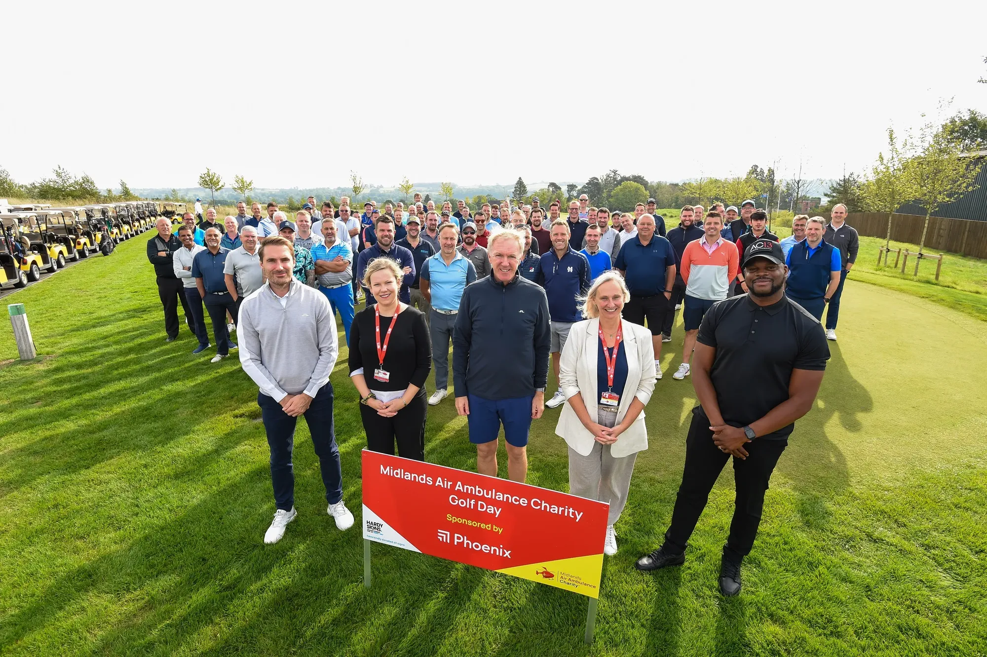 Maac Group Of People Standing In A Field With A Sign