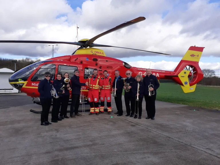 Maac Group Of People Standing In Front Of A Helicopter