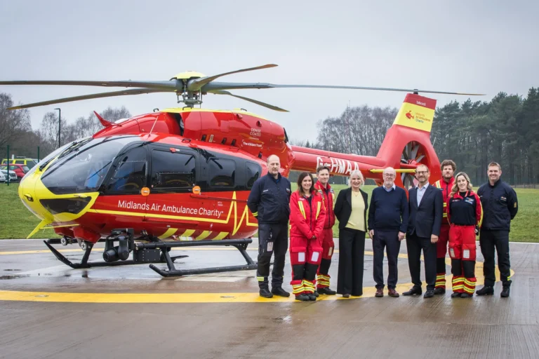 Maac Group Of People Standing In Front Of A Helicopter