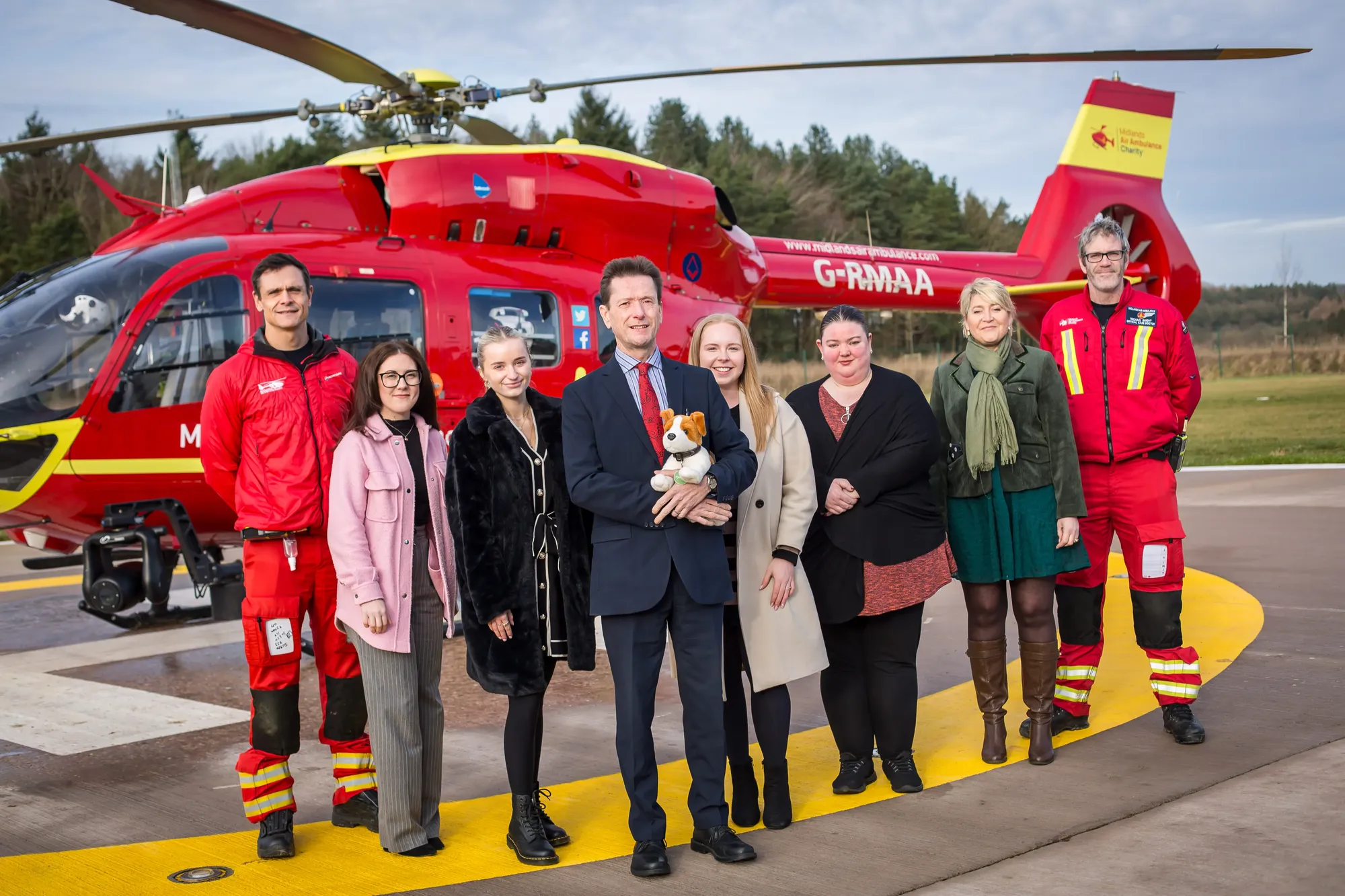 Maac Group Of People Standing In Front Of A Helicopter