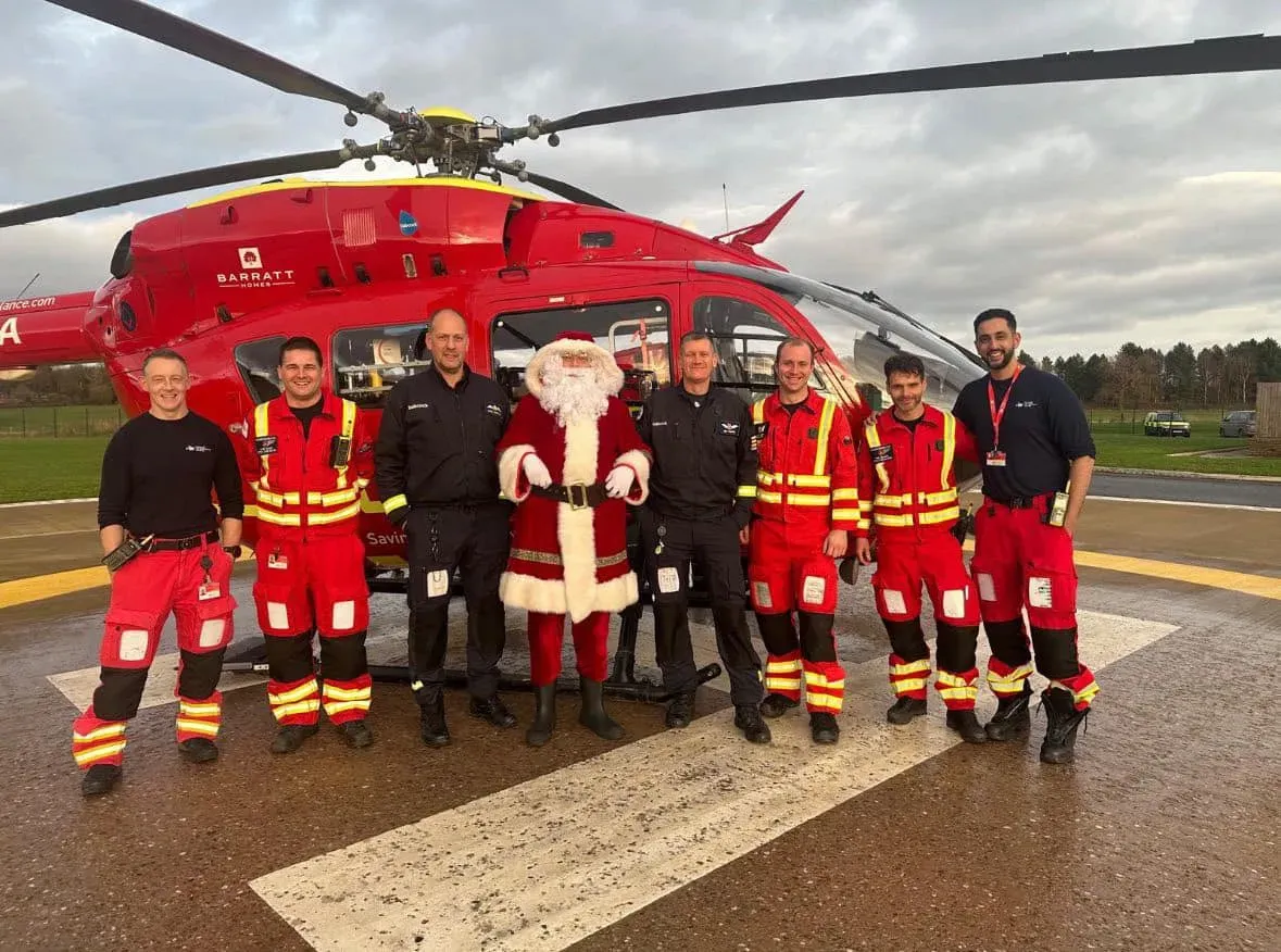 Maac Group Of People Standing In Front Of A Helicopter
