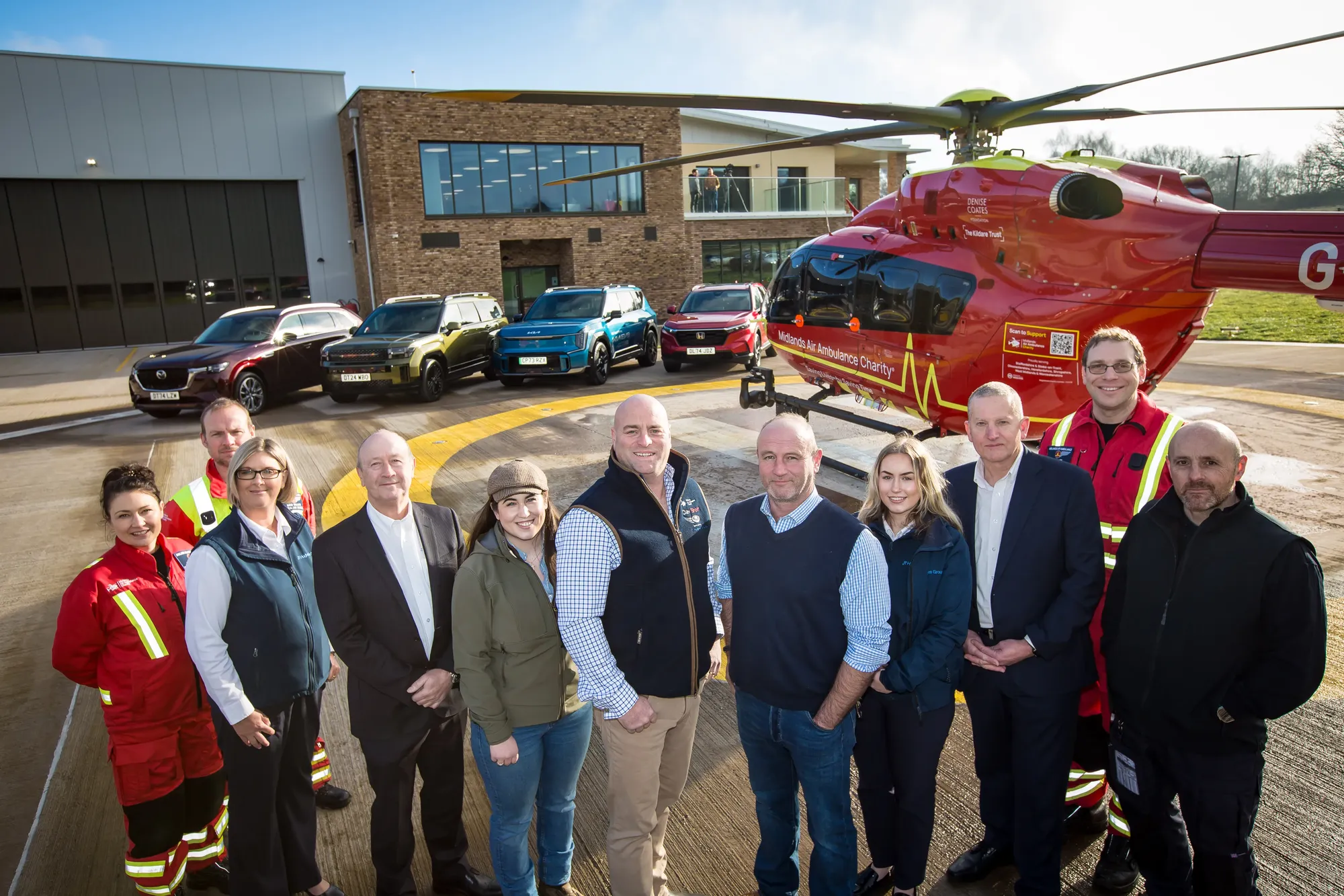 Maac Group Of People Standing In Front Of A Helicopter