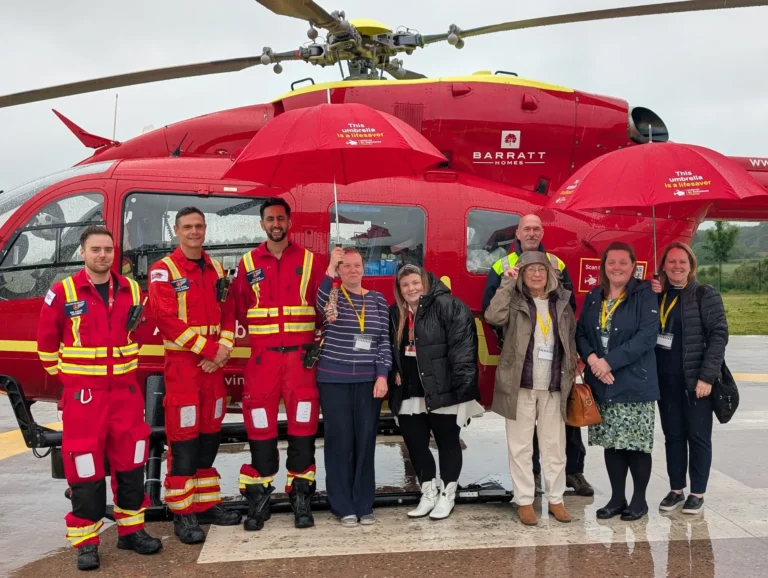 Maac Group Of People Standing In Front Of A Helicopter