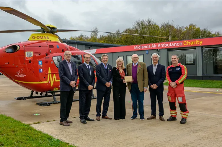 Maac Group Of People Standing In Front Of A Helicopter
