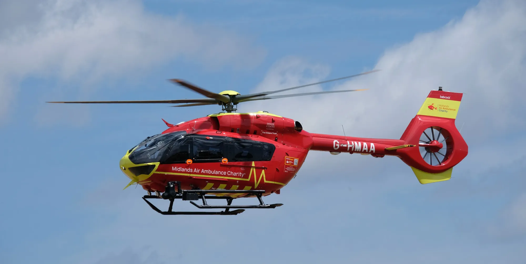 Maac Helicopter Flying In The Air With A Red And Yellow Helicopter