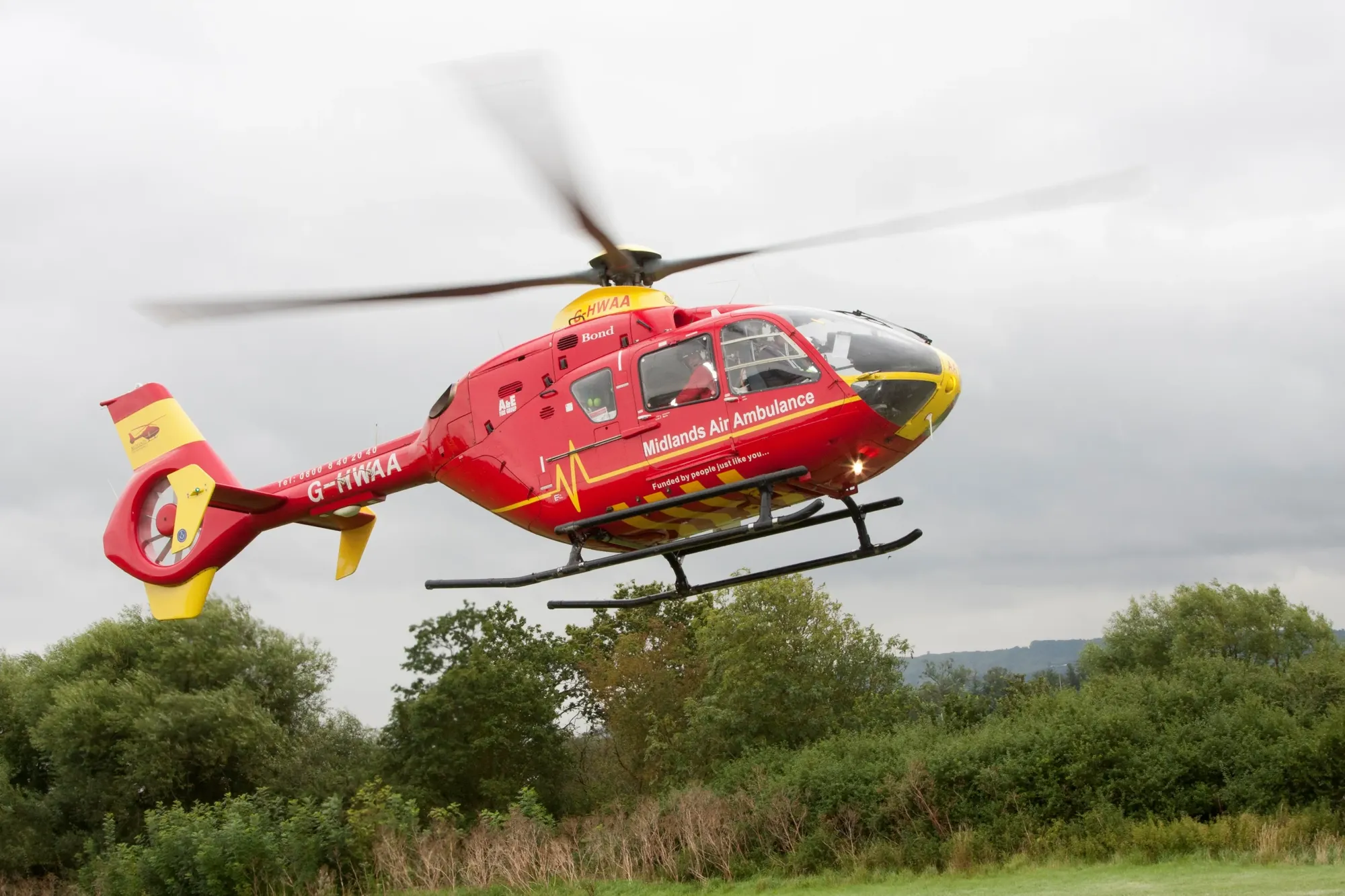 Maac Helicopter Flying In The Air With A Red And Yellow Helicopter