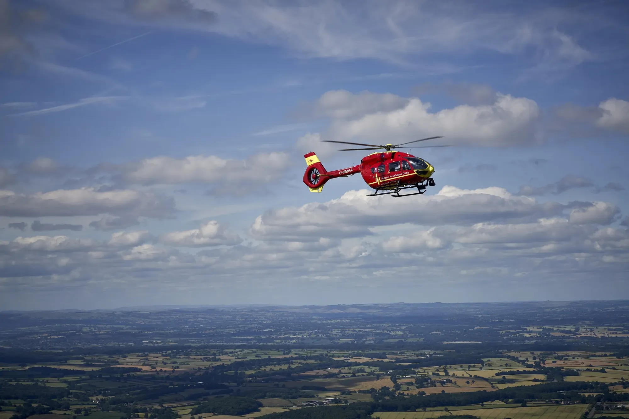 Maac Helicopter Flying In The Sky With A View Of A Valley Below