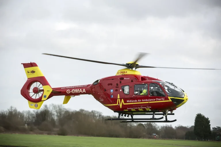 Maac Helicopter Flying Low Over A Field With A Person In The Cockpit