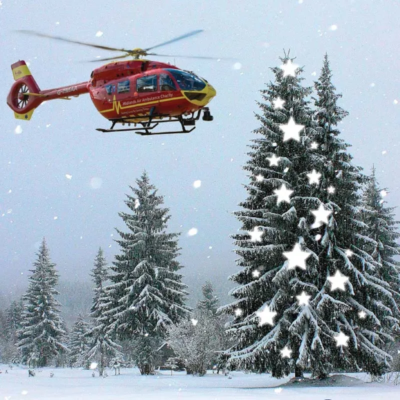 Maac Helicopter Flying Over A Snowy Forest With A Christmas Tree