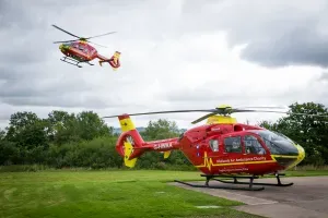 Maac Helicopter Landing On A Runway With A Helicopter Flying Overhead