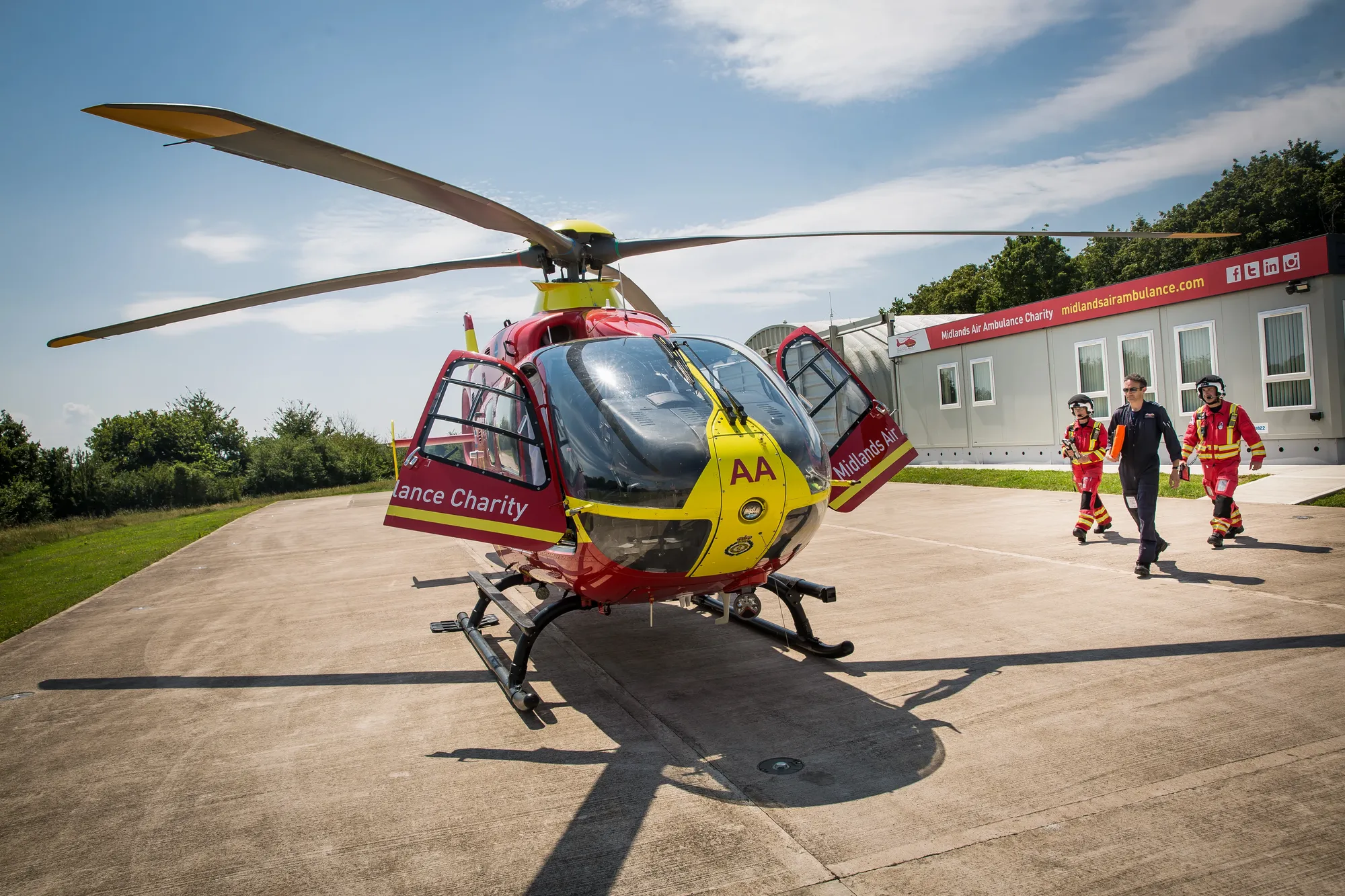Maac Helicopter On A Runway With People Walking Around It