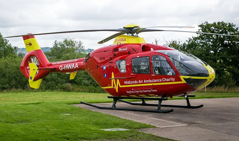 Maac Helicopter On The Ground With A Man Standing Beside It