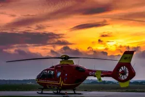 Maac Helicopter On The Runway At Sunset With Clouds In The Background