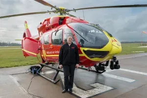 Maac Helicopter On The Runway With A Man Standing Next To It