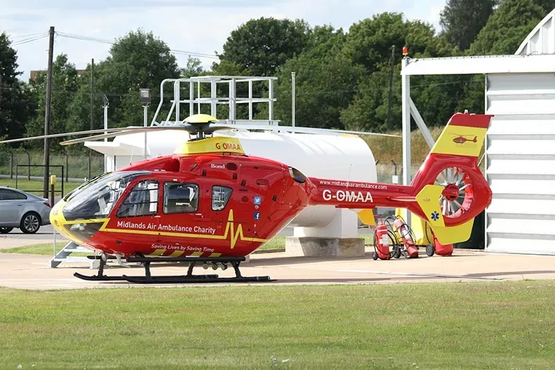 Maac Helicopter Parked On The Ground Next To A Building