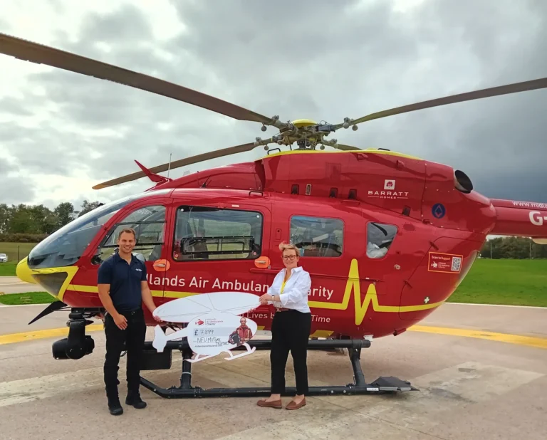 Maac Helicopter With A Man And Woman Standing Next To It
