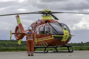 Maac Helicopter With A Man Standing Next To It On A Tarmac