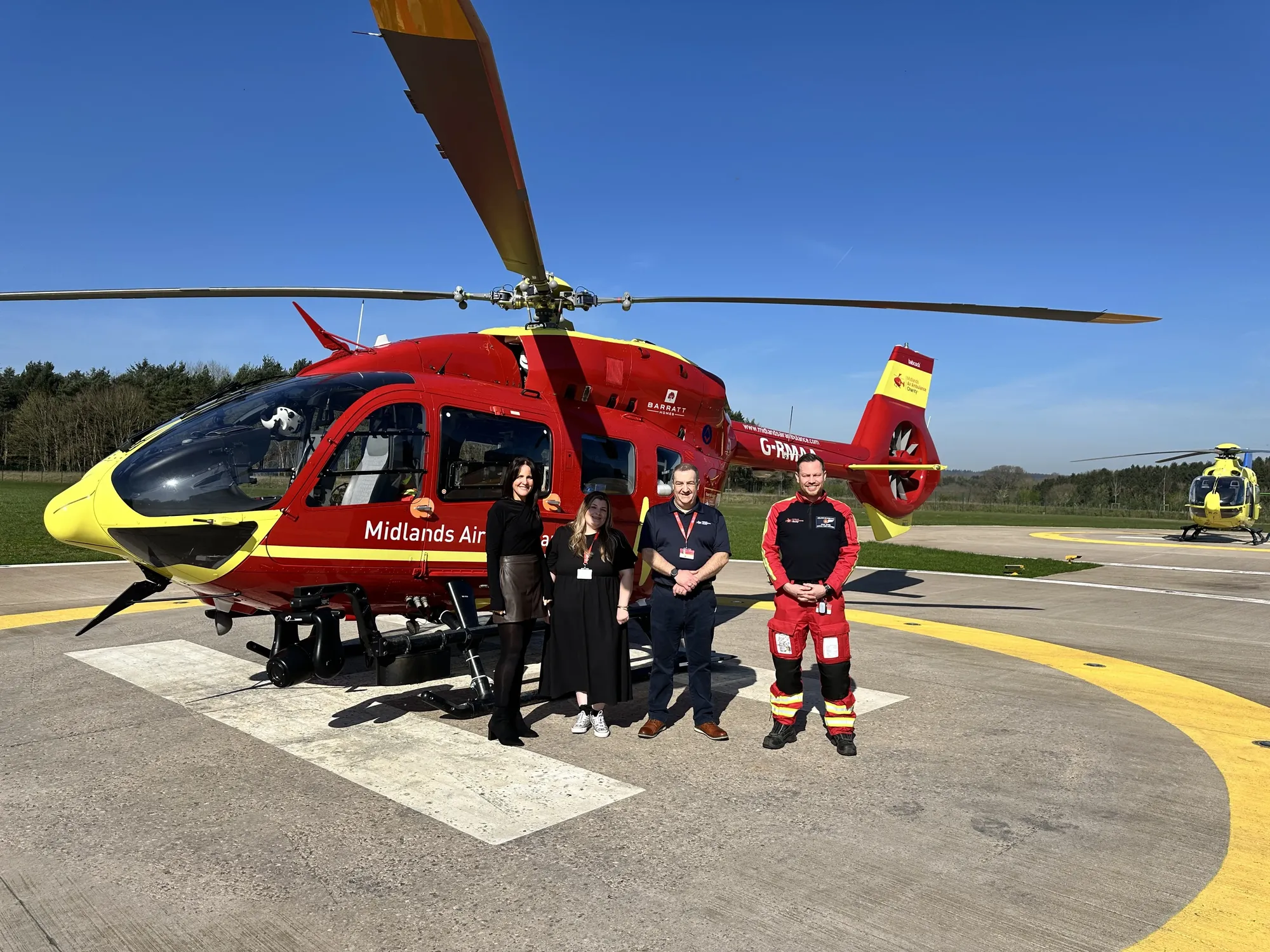Maac Maac Rescue Team Standing In Front Of A Helicopter On A Runway Rescue Team Standing In Front Of A Helicopter On A Runway