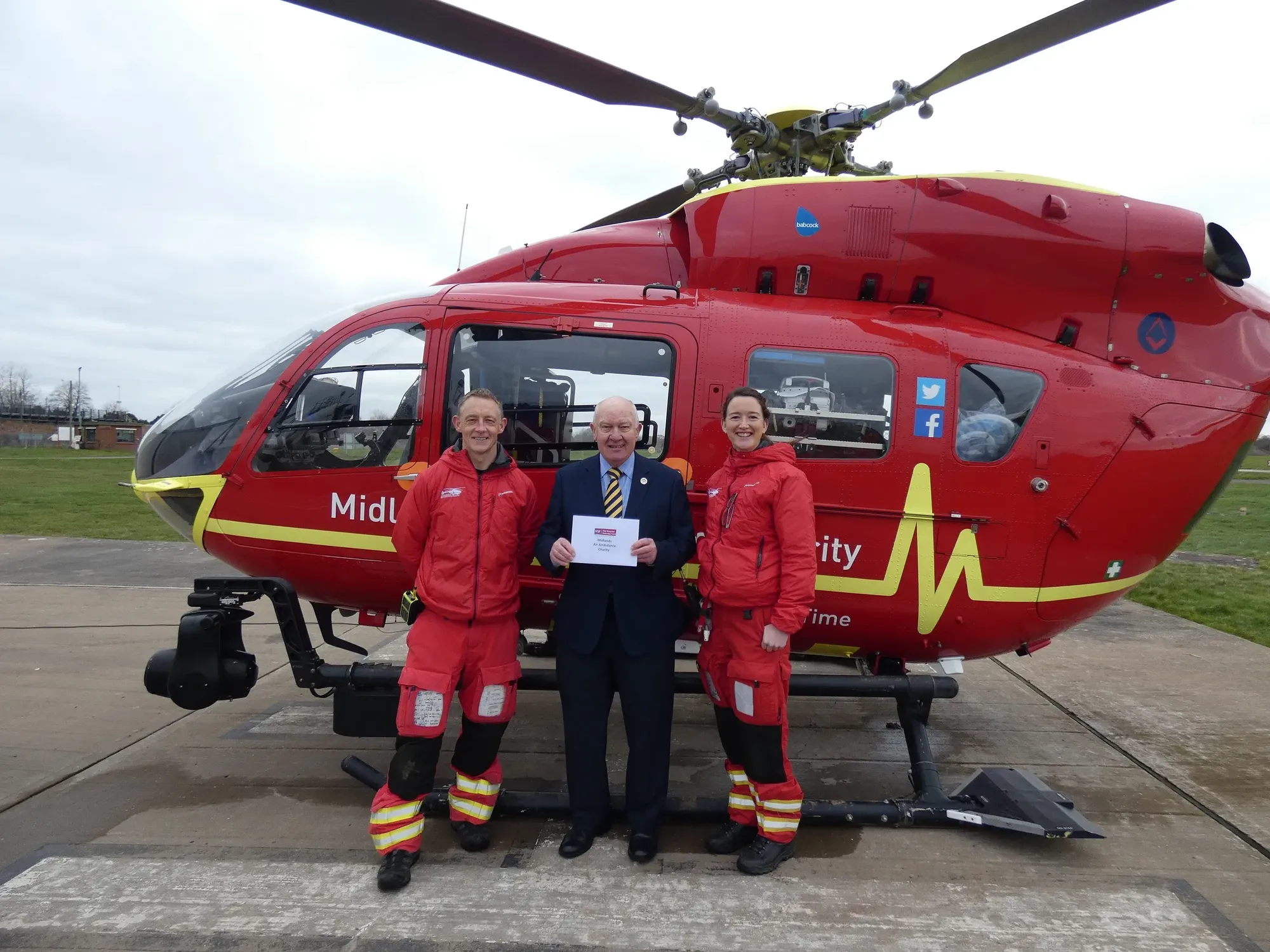 Maac Man And Two Women Standing In Front Of A Helicopter