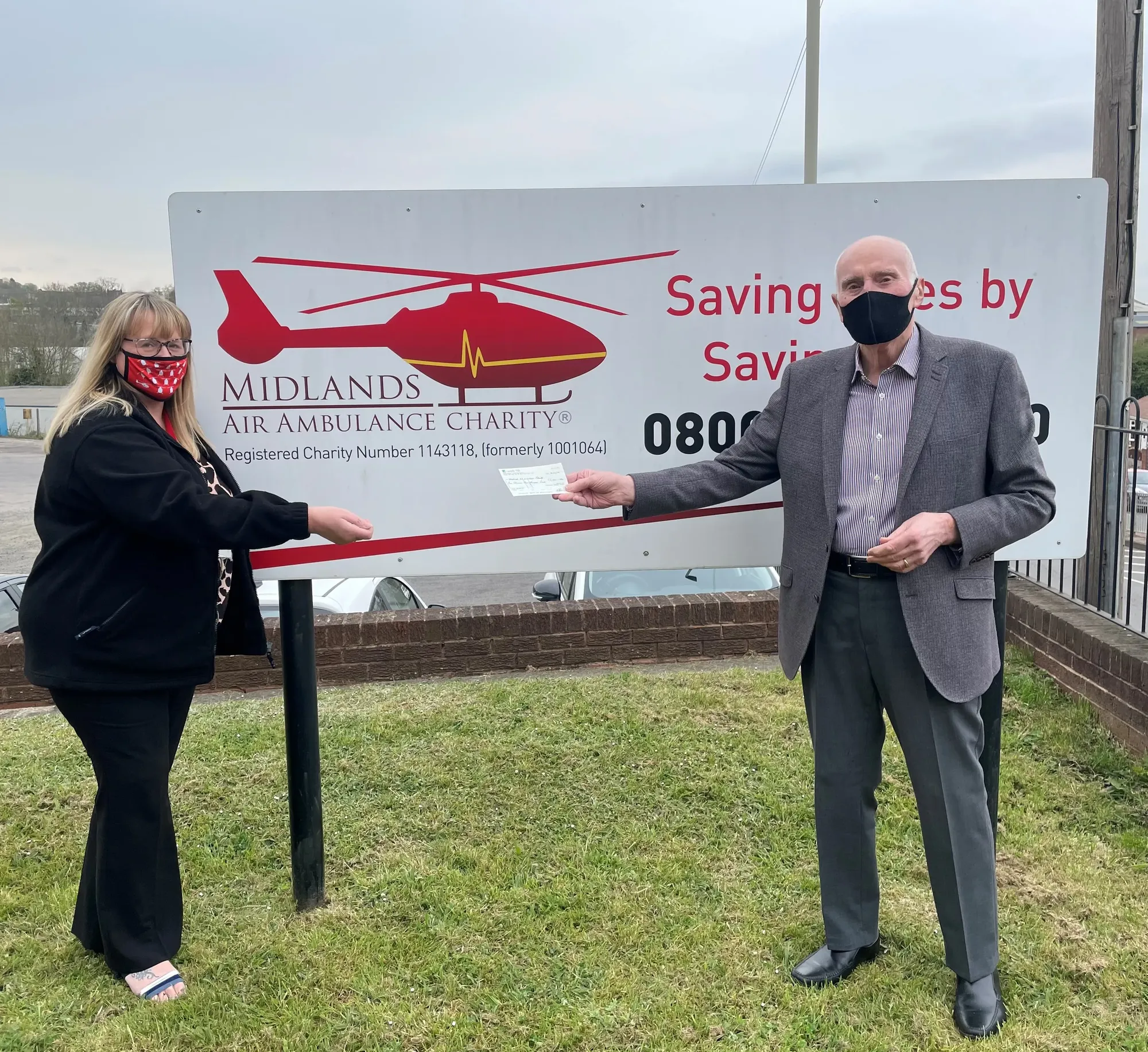 Maac Man And Woman Standing In Front Of A Sign With A Helicopter On It