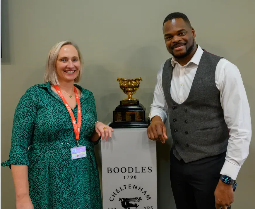 Maac Man And Woman Standing Next To A Trophy In A Room