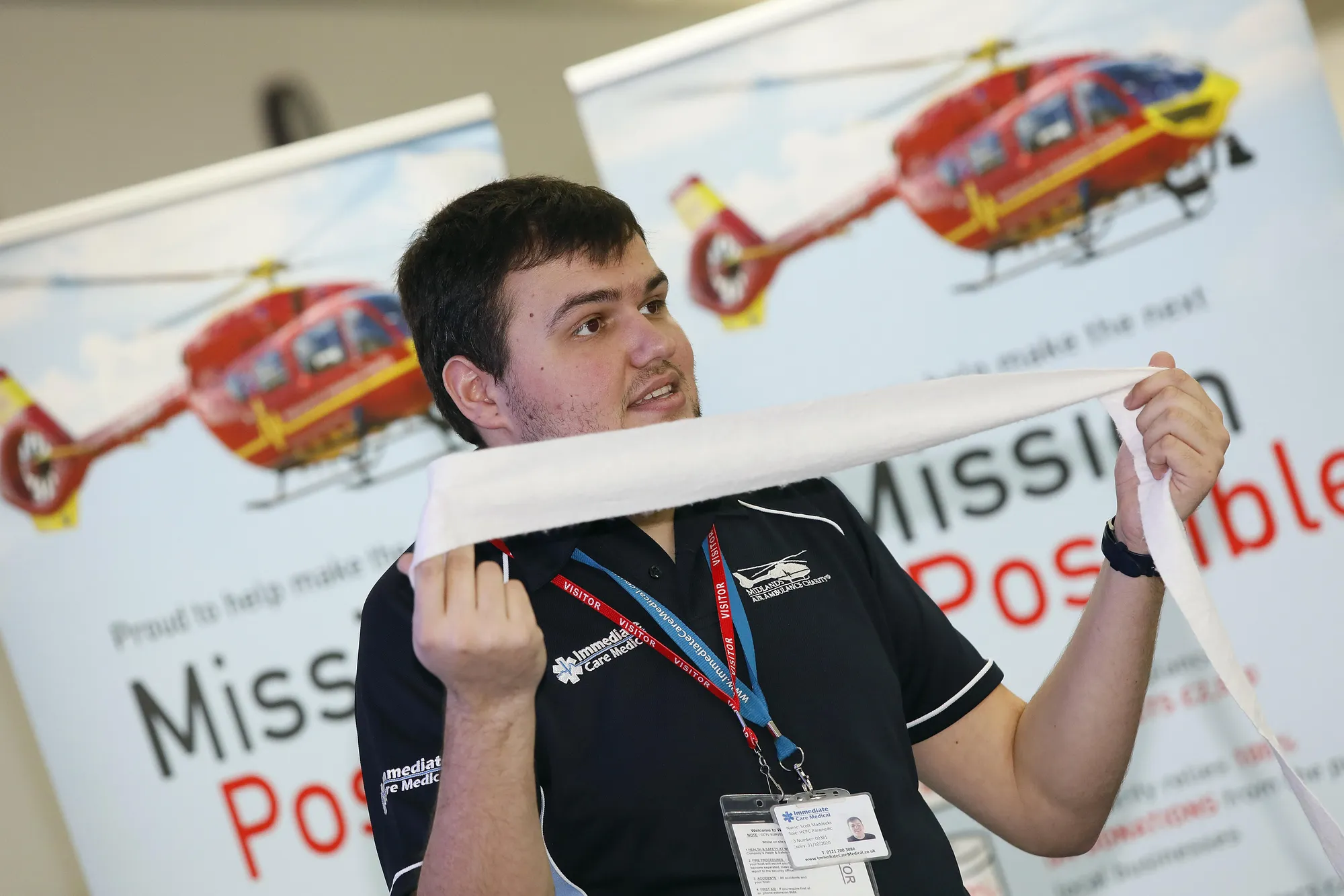Maac Man Holding A Large Piece Of Paper In Front Of A Poster