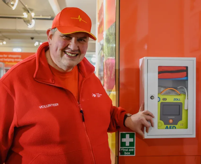 Maac Man In A Red Jacket And A Red Hat Is Standing Next To A Vending Machine