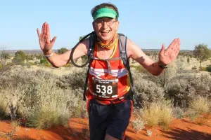 Maac Man In A Red Shirt And Green Headband Running In The Desert