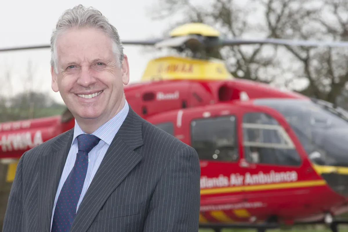 Maac Man In A Suit And Tie Standing In Front Of A Helicopter