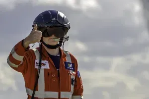Maac Man In An Orange Jacket And Helmet Giving A Thumbs Up