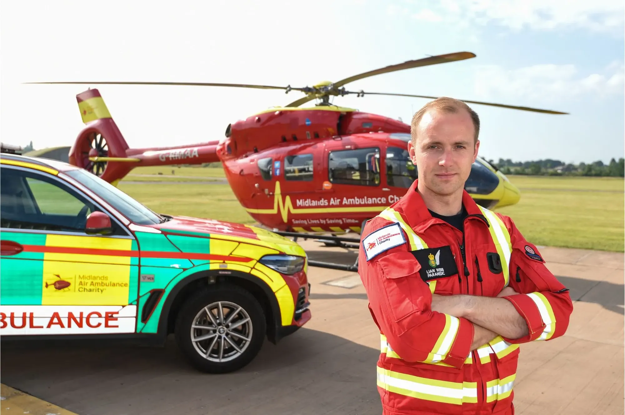 Maac Man In Red Uniform Standing Next To A Car And Helicopter