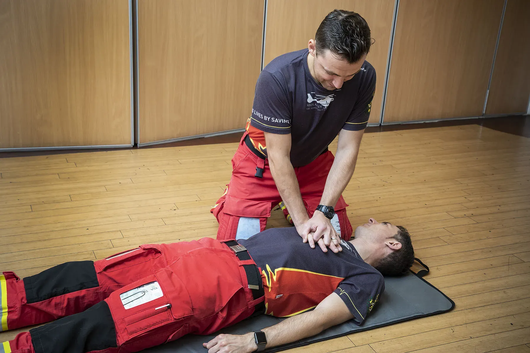 Maac Man On A Mat Being Assisted By A Firefighter