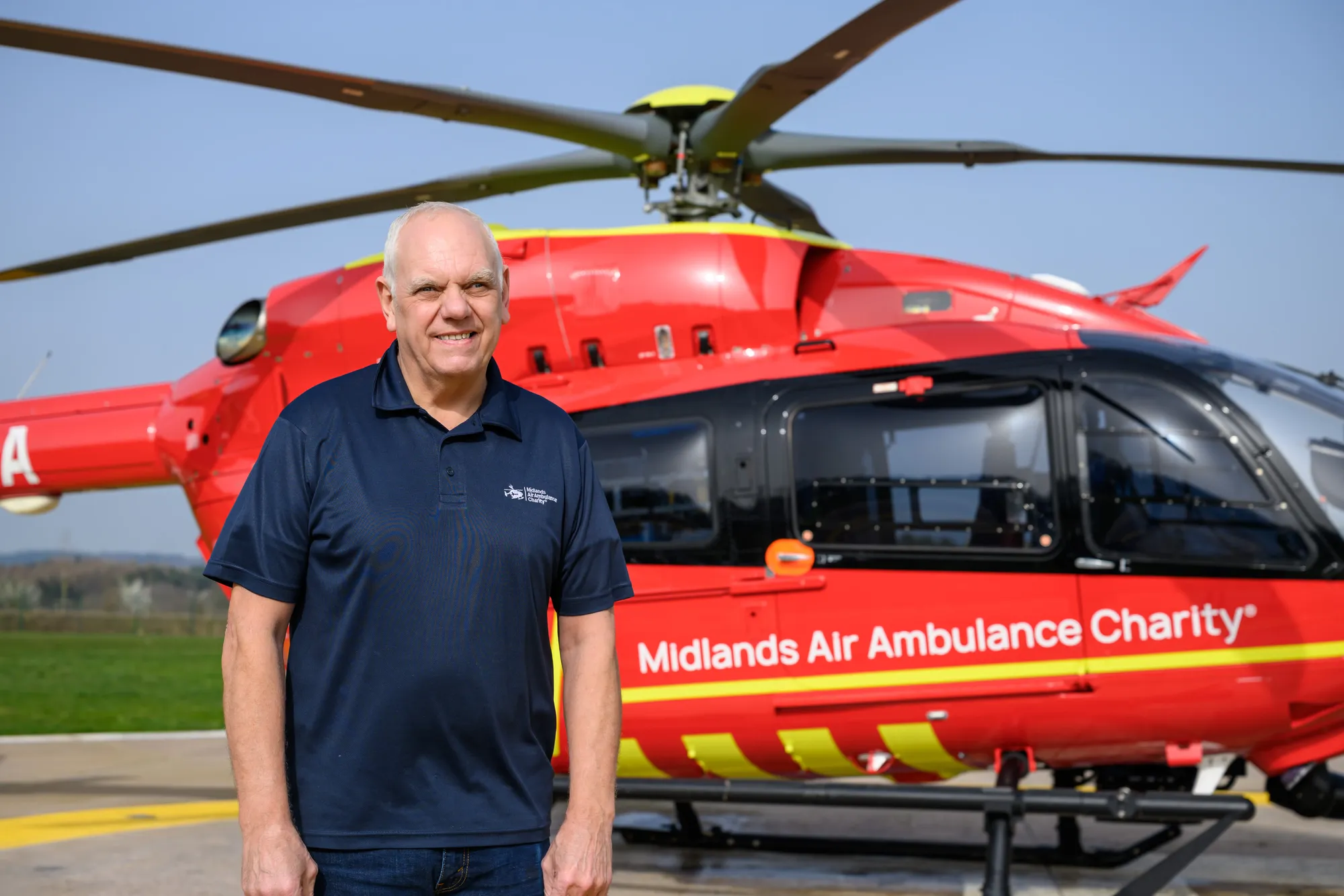 Maac Man Standing In Front Of A Helicopter On A Runway