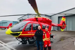 Maac Man Standing Next To A Red Helicopter In A Parking Lot