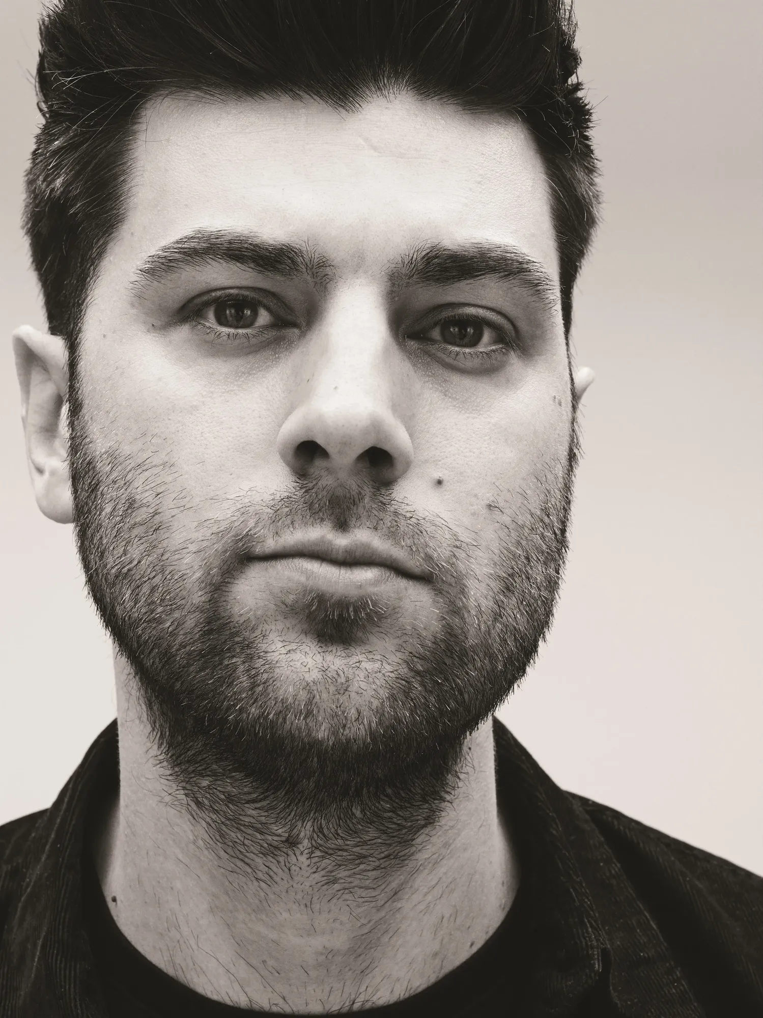 Maac Man With A Beard And A Black Shirt Looking At The Camera