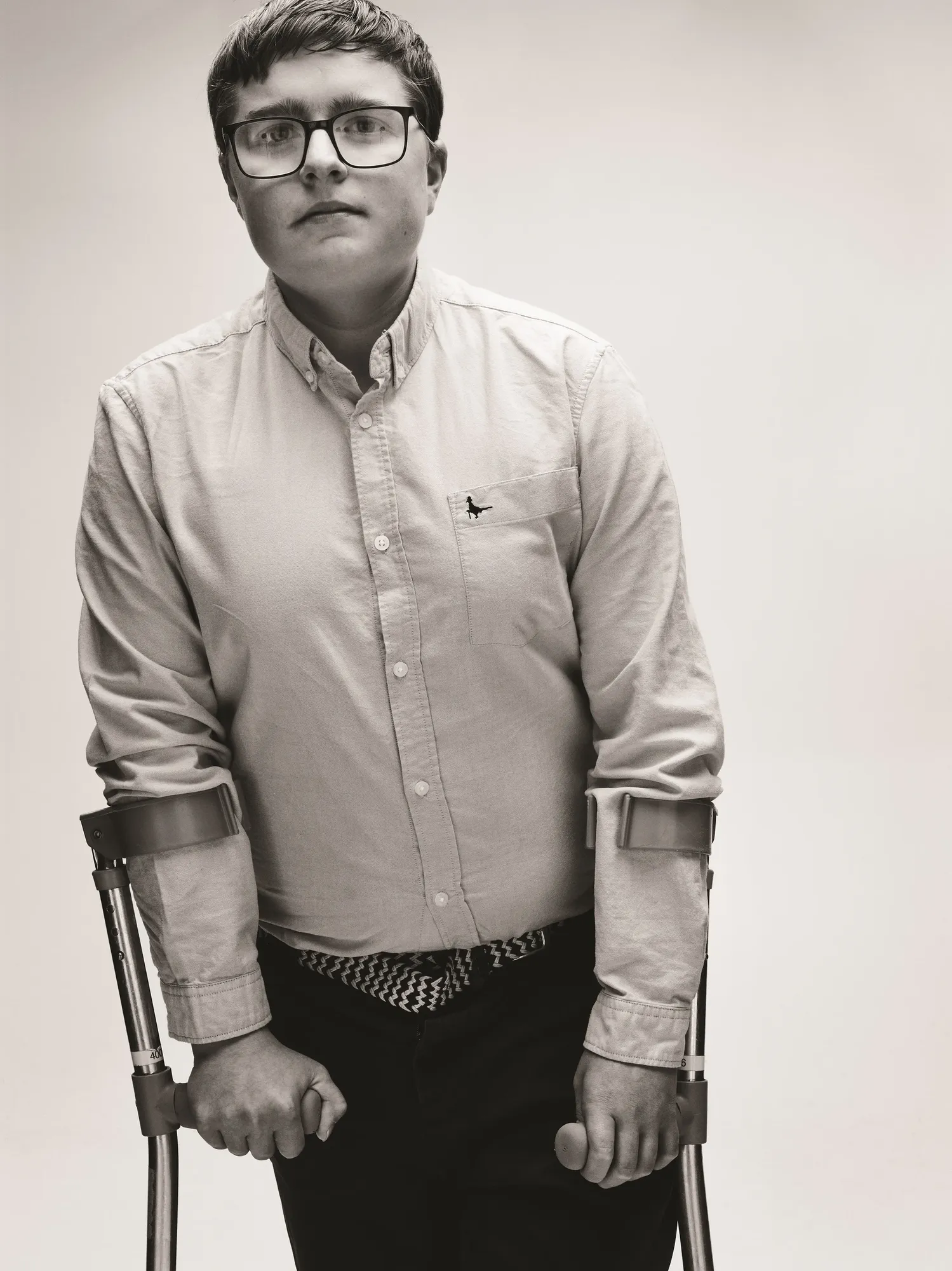 Maac Man With Glasses And A Tie Standing In A Chair