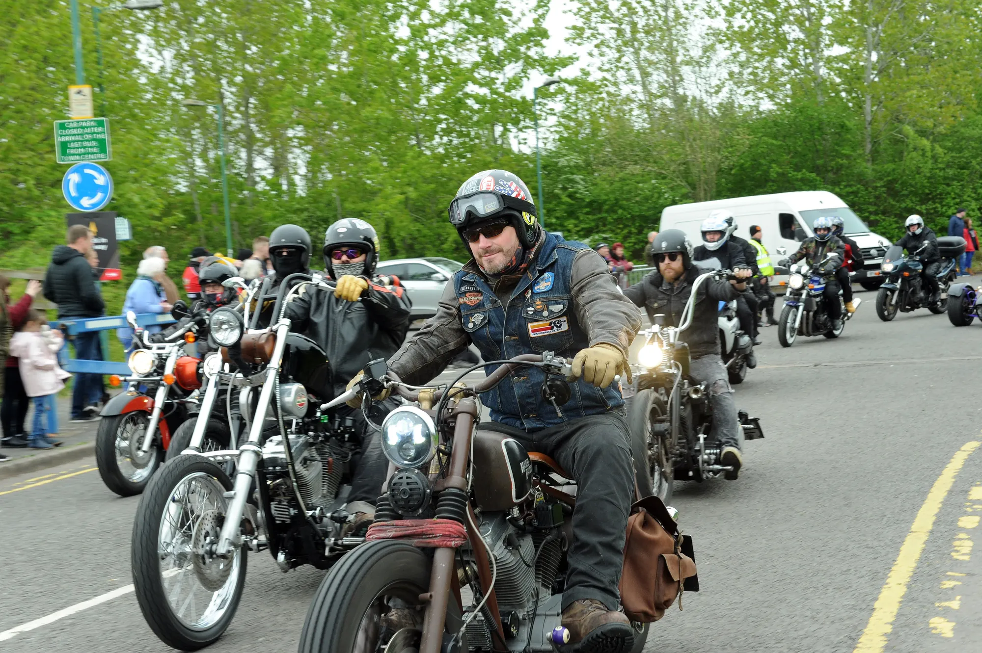 Maac Motorcycles Are Lined Up On The Street As People Watch